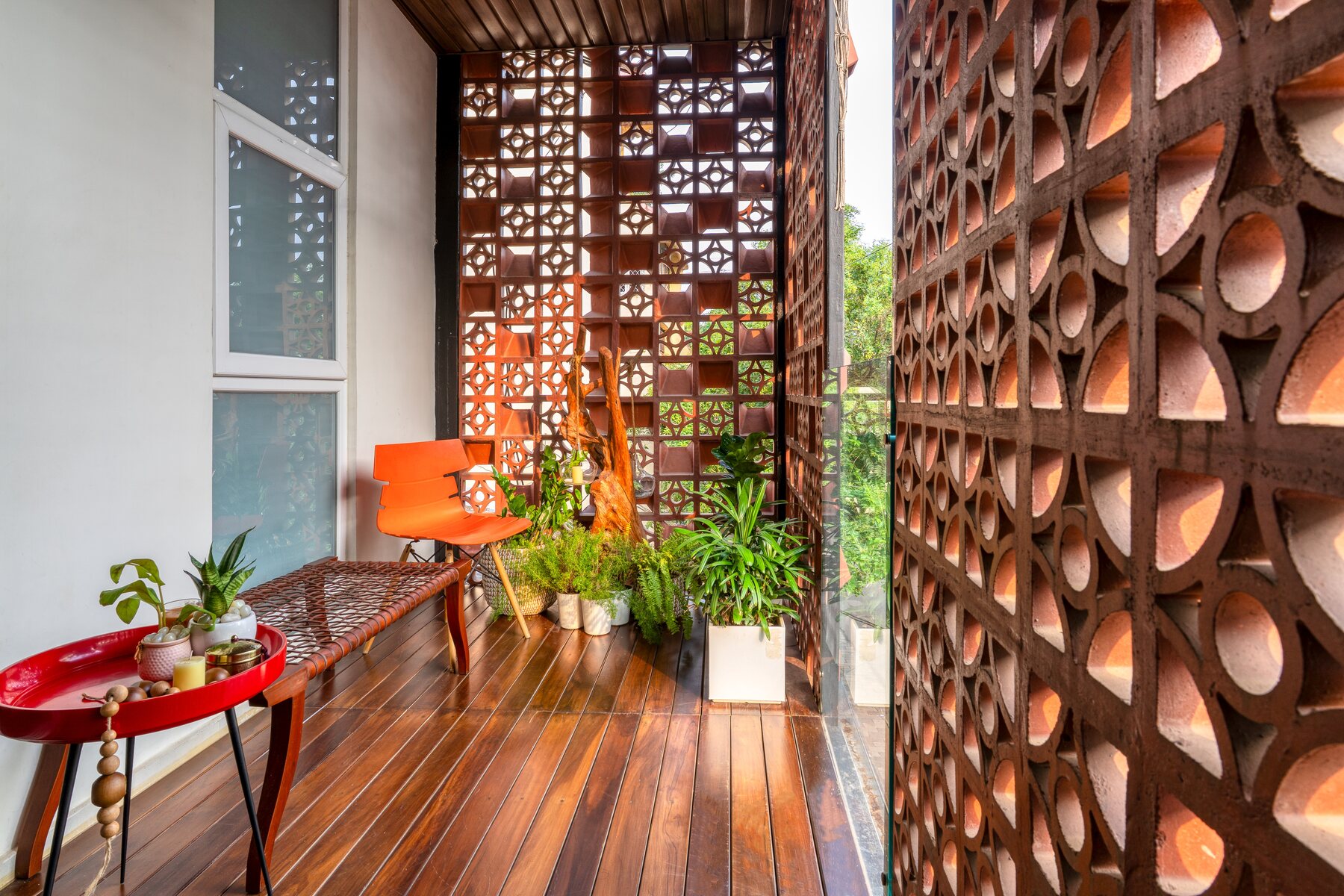 Balcony with terracotta jaali walls, timber decking and planting